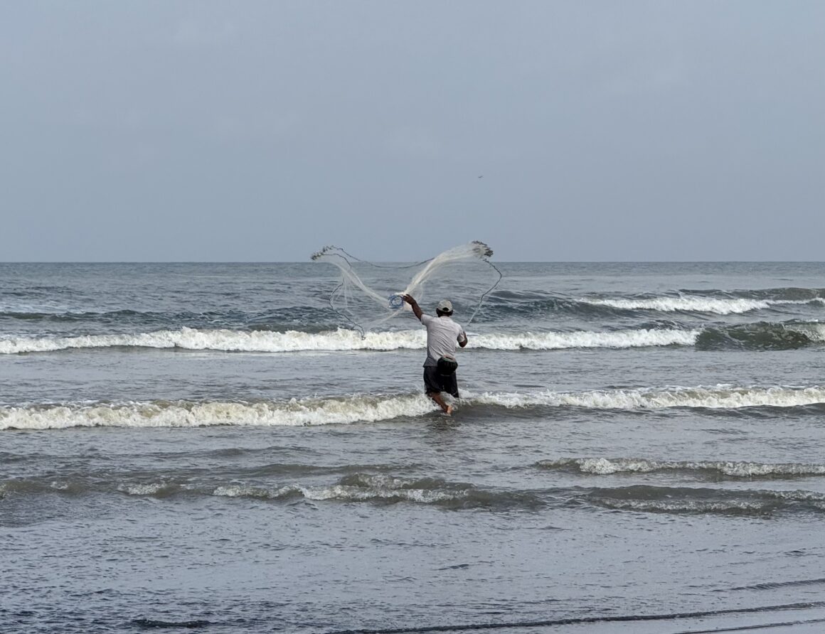 fisherman casting a net in bali indonesia